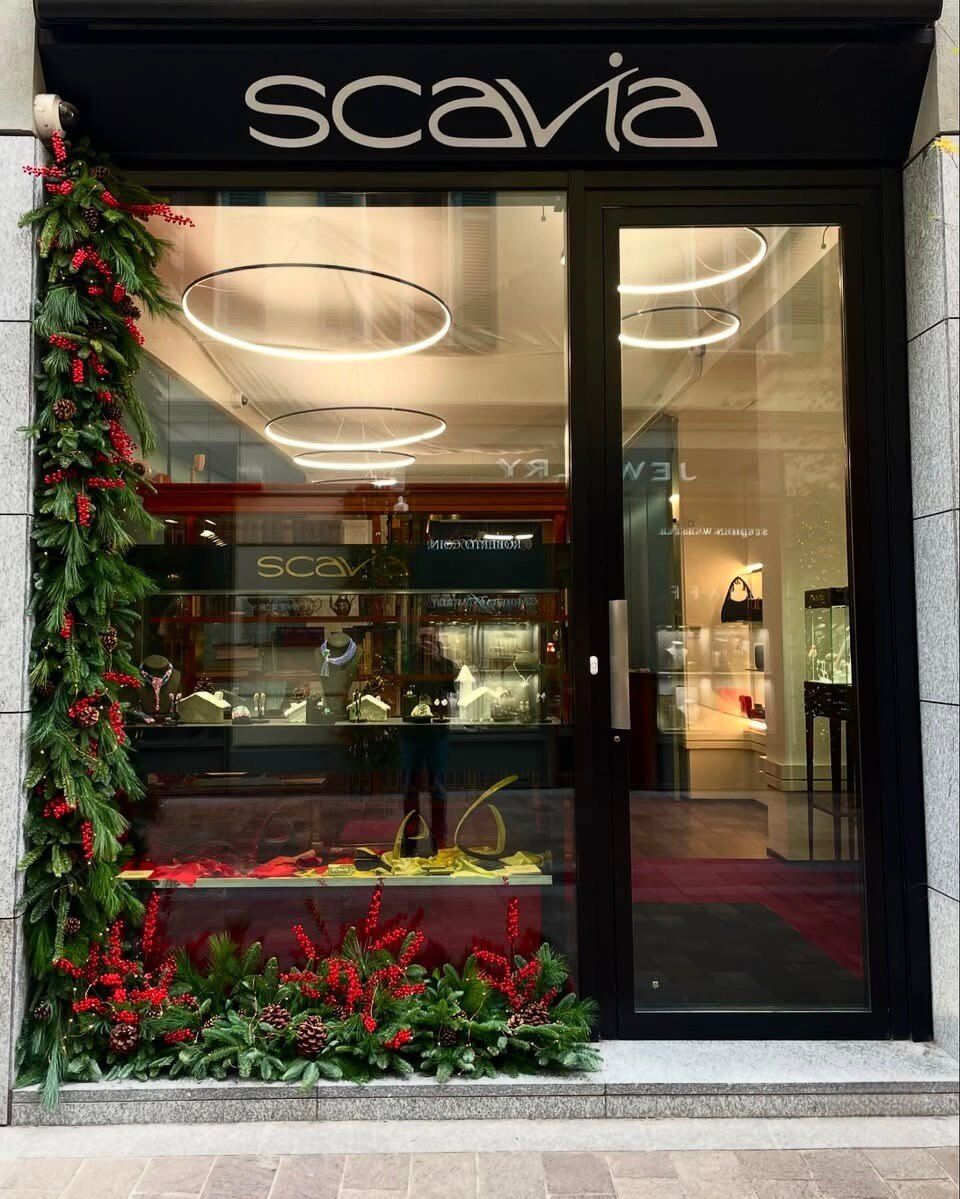 Ghirlanda di fiori rossi e verde attorno a una vetrina